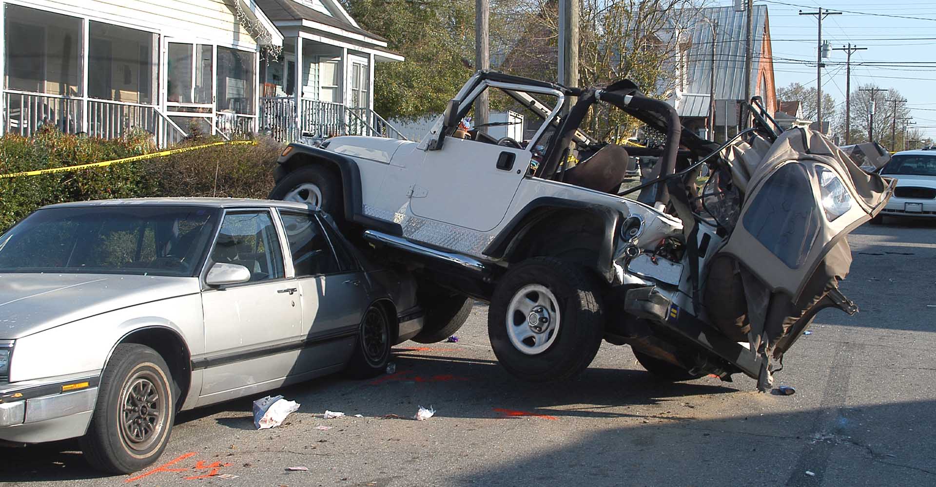 Jeep wrecked on top of sedan